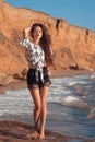 Sexy brunette summer girl in fashion casual outfit enjpying on the beach at sunset. Freedom summertime vacation concept. Enjoyment Royalty Free Stock Photo