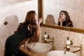 Sexy brunette woman in black dress sitting on the washbasin Royalty Free Stock Photo