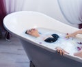 brunette woman relaxing in hot milk bath with flowers Royalty Free Stock Photo