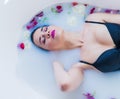 brunette woman relaxing in hot milk bath with flowers Royalty Free Stock Photo