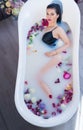brunette woman relaxing in hot milk bath with flowers Royalty Free Stock Photo