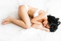 brunette woman sleeping on the white sheets