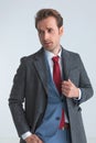 Sexy businessman arranging his coat, sticking one hand in pocket Royalty Free Stock Photo