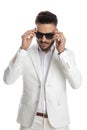 Sexy businessman arranging his sunglasses with style Royalty Free Stock Photo