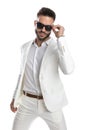 Businessman arranging his sunglasses and wearing a white suit Royalty Free Stock Photo