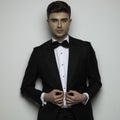Sexy businessman in black tuxedo unbuttoning his suit Royalty Free Stock Photo