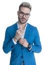 Sexy businessman in suit holding hands and arranging bracelet Royalty Free Stock Photo