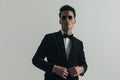 Sexy businessman with sunglasses unbuttoning black tuxedo Royalty Free Stock Photo