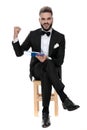Businessman sitting and holding clipboard while aggressive raising fist
