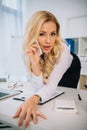 sexy businesswoman leaning on table and talking