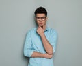 sexy casual guy with glasses touching chin and thinking Royalty Free Stock Photo