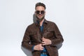Sexy casual man closing his brown leather jacket Royalty Free Stock Photo