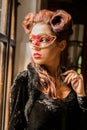 Caucasian model with carnival red mask looking through the Royalty Free Stock Photo