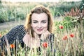 caucasian woman and corn poppy flowers, blue filter Royalty Free Stock Photo