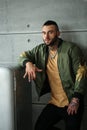 closeup portrait of elegant handsome male model with fashion tattoo and a black beard standing and posing near Stylish old re Royalty Free Stock Photo