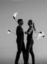 Sexy couple of fire dancers spin flaming poi on idyllic evening blue sky outdoors, motion Royalty Free Stock Photo