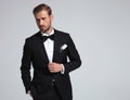 elegant man wearing tuxedo and bowtie posing Royalty Free Stock Photo