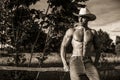 farmer or cowboy next to hay field