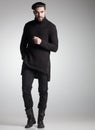 fashion man model in black sweater, jeans and boots posing dramatic