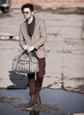 fashion man model dressed vintage elegant holding a bag posing outdoor