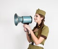 fashionable woman in military uniform and garrison cap, holding bullhorn and screaming Royalty Free Stock Photo