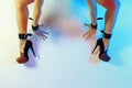 female legs in high heel shoes and leather cuffs chained together with hands in cuffs Royalty Free Stock Photo