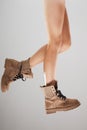 Sexy female legs wearing boots against gray background Royalty Free Stock Photo