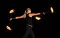 Sexy fire dancer manipulate burning batons during night performance in dark outdoors, party Royalty Free Stock Photo