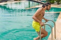 young man getting out of the swimming pool in a resort Royalty Free Stock Photo