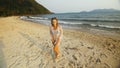 Woman in a white tunic on the beach, near the stormy sea. Blonde Royalty Free Stock Photo