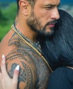 Sexy and fit woman and hugging handsome man with tattoo. Passion and sensual touch. Young couple in love hug each other