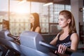 fit women running on treadmills in modern gym. Healthy young girls doing running exercise on treadmill in gym.