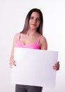 fitnes brunette in a tracksuit holding empty white board