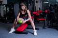 fitness woman in sportswear resting after dumbbells exercises in gym. Beautiful girl with perfect fitness body drinking from Royalty Free Stock Photo