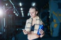 fitness woman in sportswear resting after dumbbells exercises in gym. Beautiful girl with shaker and towel. Royalty Free Stock Photo