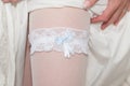 Sexy garter placed on a bride`s leg. Part of a girl`s body. Royalty Free Stock Photo