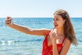 girl on a beach with surprised expression looking at phone and taking selfie Royalty Free Stock Photo