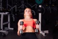 girl doing exercises in her pectoral muscle. fitness with dumbbells in the gym. nice cute female. Royalty Free Stock Photo