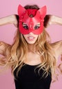 Sexy girl with long blond hair in red cat mask. Christmas masquerade party. Catwoman with festive makeup. Sensual woman Royalty Free Stock Photo