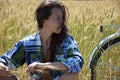 Sexy girl looking away while relaxing in wheat field. woman relax after riding bicycle. bike trip in rye field. have a little Royalty Free Stock Photo