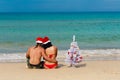 girl man Santa on a beach fir-tree Royalty Free Stock Photo