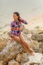 girl posing sitting on rocks at the beach Royalty Free Stock Photo