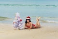 girl Santa in bikini on a beach fir-tree Royalty Free Stock Photo