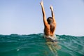 girl swim sea waves hands up splash back view Royalty Free Stock Photo