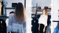 A sexy girl, tall, handsome blonde woman trying on outfits in a store and admiring herself in front of a mirror, smiles Royalty Free Stock Photo