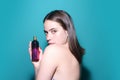 Sexy girl using parfume. Young beautiful woman with a bottle of perfume. Model with healthy skin, close up beauty