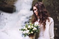 girl with a wedding bouquet of flowers against the background of a glacier and mountains Royalty Free Stock Photo