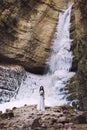 A girl in a wedding dress with a bouquet of flowers on a background of a glacier and mountains Royalty Free Stock Photo