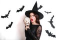 Happy gothic young woman in witch halloween costume with hat standing and having fun over white background Royalty Free Stock Photo