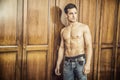 handsome young man standing shirtless against wardrobe Royalty Free Stock Photo